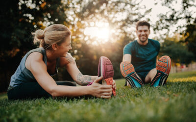 young couple stretching outdoors in park