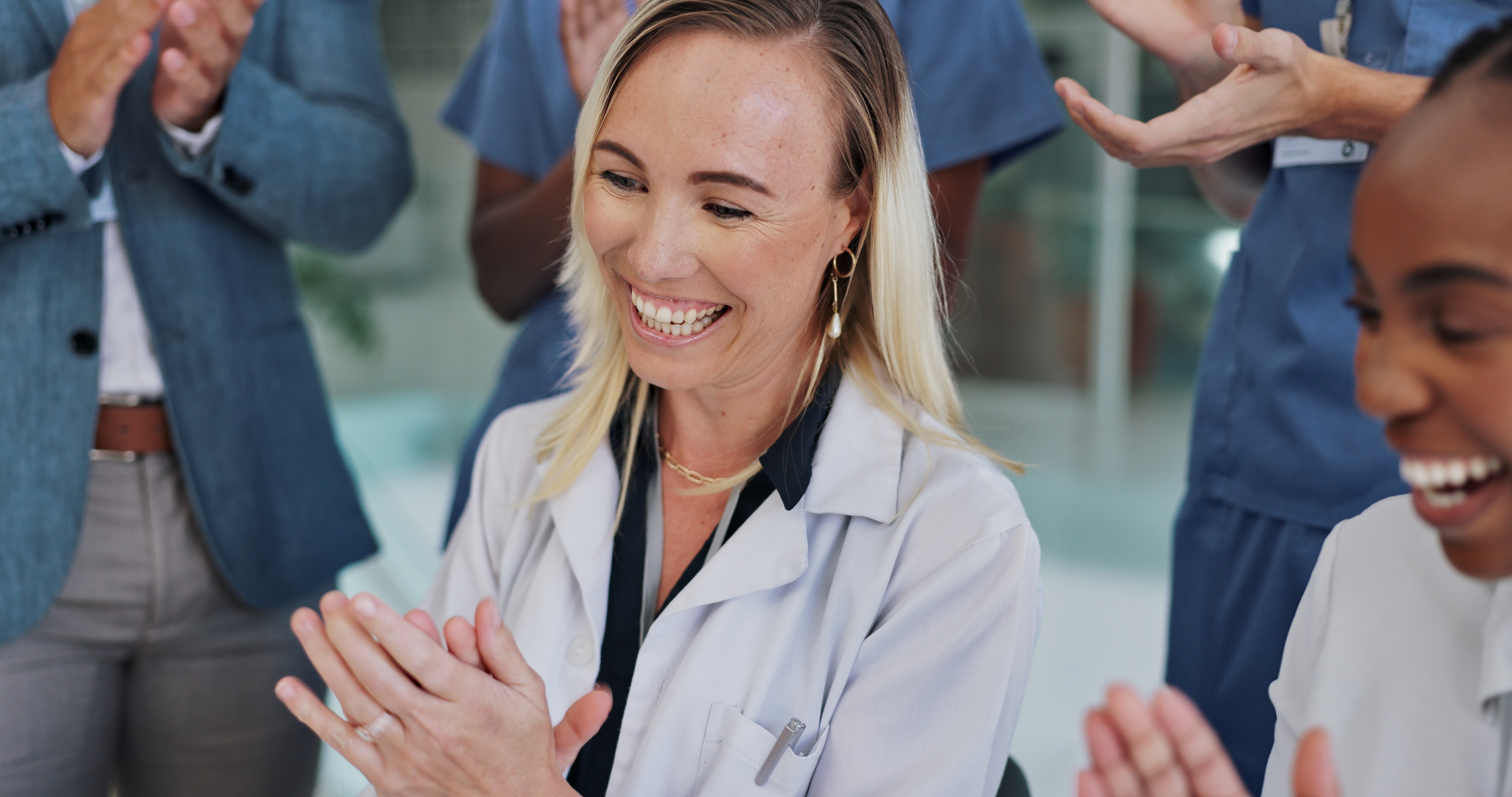 Doctor, woman and clapping for teamwork, celebration and success or news of clinical trial results in liver cancer vaccine. Excited group or medical staff applause or praise for healthcare excellence
